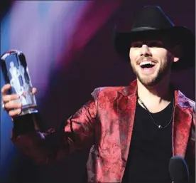  ?? The Canadian Press ?? Left, Brett Kissel accepts his award at the Juno Awards in London, Ont., on Sunday. Right, Jessie Reyez accepts her award from Sting and David Foster, not shown, at the Juno Awards.