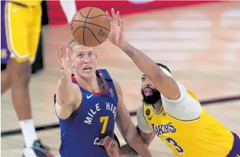  ?? Mark J. Terrill, The Associated Press ?? Denver’s Mason Plumlee ( 7) and Los Angeles’ Anthony Davis ( 3) fight for a loose ball during Friday night’s game in Lake Buena Vista, Fla.
