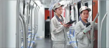  ?? CHEN ZEGUO / XINHUA ?? Employees from CRRC Zhuzhou Locomotive Co inspect a compartmen­t of the firm’s first train to be exported to Mexico City, in Zhuzhou, Hunan province, last September.