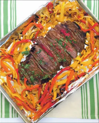  ?? PHOTO BY CATHY THOMAS ?? Fajita flank steak with peppers and onions is tasty stuffed between warm tortillas.