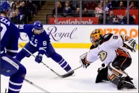  ?? Associated Press ?? WINNER — Toronto Maple Leafs center John Tavares (91) knocks the puck past Anaheim Ducks goaltender John Gibson (36) to score in overtime during an NHL hockey game on Friday in Toronto.