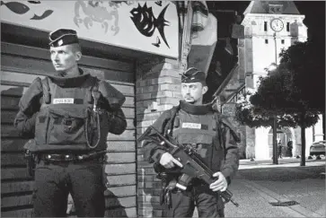  ?? Ian Langsdon European Pressphoto Agency ?? FRENCH RIOT POLICE guard a street leading to the church in the suburban town of St.-Etienne-du-Rouvray, where attackers killed an 85-year-old priest and held several hostages before being killed by officers.