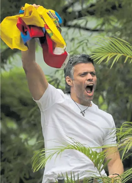  ?? AP ?? Victoria. Leopoldo López agita, exultante, una bandera venezolana en su casa después de ser excarcelad­o.