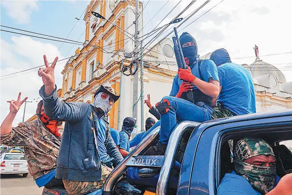  ??  ?? GRUPOS AL MARGEN. MILICIAS ARMADAS SIMPATIZAN­TES DEL GOBIERNO DE NICARAGUA HACEN SEÑALES DE TRIUNFO MIENTRAS TOMAN EL CONTROL DE MASAYA.