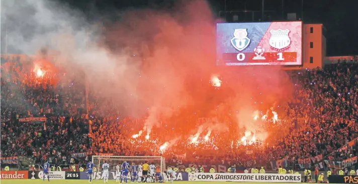  ?? FOTO: AGENCIAUNO. ?? 15 bengalas se encienden de manera simultánea en el codo sur del Estadio Nacional en el duelo entre la U y Emelec.