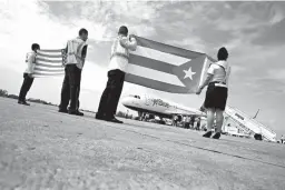  ?? Associated Press ?? In this Aug. 31, 2016, file photo, airport workers receive JetBlue flight 387, the first commercial flight between the U.S. and Cuba in more than a half-century, holding United States and Cuban national flags on the airport tarmac in Santa Clara, Cuba....