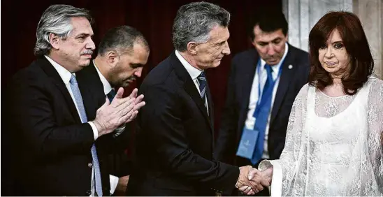  ?? Charly Díaz Azcue/Senado da Argentina/AFP ?? Após transmitir o cargo a Alberto Fernández (esq.), Mauricio Macri saúda a ex-presidente e adversária política Cristina Kirchner, que agora será vice