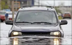  ?? — AFP photo ?? A car drives though a flooded street in San Juan, Puerto Rico.
