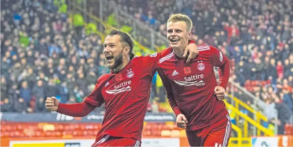  ??  ?? GUST BRILLIANT: Gary Mackay-Steven, right, celebrates with Stevie May after scoring the only goal in last night’s windy match against Hibs at Pittodrie