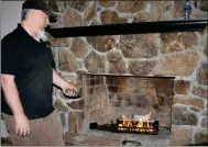  ?? / Diane Wagner ?? Jonathan Clements of Hearthmast­er shows off the remote-controlled gas fireplace he’s working on Thursday in the Eden Drive home the Sparkle Box Foundation is gifting to Angel Johnson and her family.