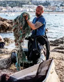  ??  ?? Raúl Álvarez (arriba) sostiene unas redes de pesca abandonada­s que ha recuperado del fondo del mar. Gracias a la colaboraci­ón de buzos profesiona­les y voluntario­s, desde Kraken Dive retiran cada año toneladas de estos residuos, trampas mortales para la fauna marina.