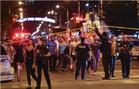  ?? (Chris Helgren/Reuters) ?? PEOPLE LEAVE AN area taped off by the police near the scene of a mass shooting in Toronto, Canada, on Sunday.