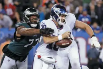  ?? JULIO CORTEZ - AP ?? Philadelph­ia Eagles defensive end Michael Bennett (77) strips the ball from New York Giants quarterbac­k Eli Manning during the first half of an NFL football game Thursday, in East Rutherford, N.J.