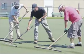  ?? CoDy MCeaCherN ?? Joey Hollis, left, and Andy Johnson from the Truro parks and recreation department and club member Peter Saunders help reset and stretch the carpet after repairs to the Cobequid Lawn Bowl Club’s green were finished on Monday afternoon.