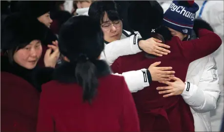  ?? Yun Dong-jin / Yonhap via AP ?? A North Korean women’s hockey team player hugs her South Korean teammates, wearing white coats, before returning to North Korea.