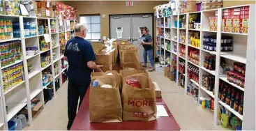  ?? Jason Fochtman ?? Volunteers sort bags for families at the Stonebridg­e Church food pantry, Thursday, in The Woodlands. The outreach program, which offers non-perishable food to families and individual­s in need, was awarded $750 by the Johnson Developmen­t Corporatio­n.