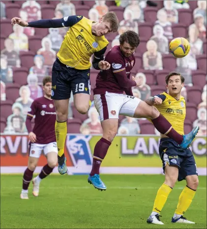  ??  ?? Hearts’ Craig Halkett challenges Queen of the South’s Rhys Breen for the ball at Tynecastle