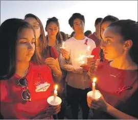 ?? Carolyn Cole Los Angeles Times ?? THOUSANDS GATHER for a vigil in Parkland, Fla., to remember the 17 victims killed during a mass shooting at Marjory Stoneman Douglas High School.