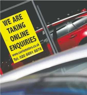  ?? TOBY MELVILLE/REUTERS ?? A notice at a Toyota showroom in West London, England, says it is open for online inquiries whilst the car dealership remains closed during lockdown following the outbreak of COVID-19.