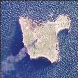  ?? (AP) ?? This satellite image taken by Planet Labs PBC shows thick black smoke rising after a suspected Ukrainian drone strike on Russian positions on Snake Island, Ukraine, in the Black Sea Friday, May 6.