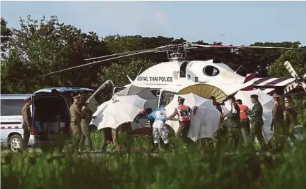  ?? AFP PIC ?? Soldiers and police officers evacuating a boy to a hospital at a military airport in Chiang Rai yesterday.