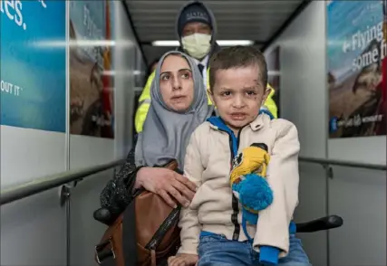  ?? Peter K. Afriyie/Associated Press ?? Four-year-old Omar Abu Kuwaik and an aunt, Maha Abu Kuwaik, are escorted through John F. Kennedy Internatio­nal Airport in New York after departing a flight from Egypt on Jan. 17. Through the efforts of family and strangers, Omar was brought from Gaza to the United States, where he received a prosthetic arm.