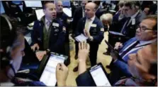  ?? RICHARD DREW — THE ASSOCIATED PRESS ?? Specialist Robert Nelson, second left, works with traders on the floor of the New York Stock Exchange, Wednesday.