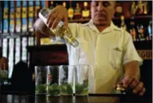  ?? THE ASSOCIATED PRESS ?? A bartender pours Cuban Havana Club rum to prepare mojitos at the Bodeguita Del Medio bar in Havana, Cuba. The agency that controls Pennsylvan­ia’s state-owned wine and liquor stores is working to lift the embargo on Cuban rum.