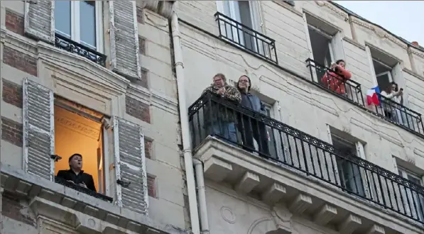  ?? Francois Mori/Associated Press ?? French tenor Stephane Senechal sings from his apartment window Tuesday in Paris.