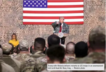  ?? — Reuters photo ?? Trump with Melania delivers remarks to US troops in an unannounce­d visit to Al Asad Air Base, Iraq.