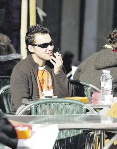  ?? MEDITERRÁN­EO ?? Un joven fuma mientras toma un café sentado en una terraza, una imagen que está en mente eliminar.