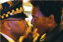  ?? AP PHOTO/CHARLES REX ARBOGAST ?? Lamon Reccord, right, stares and yells, “Shoot me 16 times,” at a Chicago police officer Nov. 25, 2015, as he and others march through Chicago’s Loop, one day after murder charges were brought against police officer Jason Van Dyke in the killing of 17-year-old Laquan McDonald.