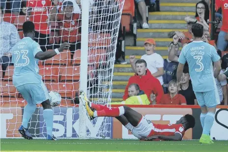  ??  ?? Ike Ugbo puts Barnsley ahead at Oakwell as Lamine Kone and Bryan Oviedo can only look on helplessly. Pictures by Frank Reid.