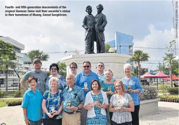  ??  ?? Fourth- and fifth-generation descendant­s of the original Siamese Twins visit their ancestor’s statue in their hometown of Muang, Samut Songkhram.