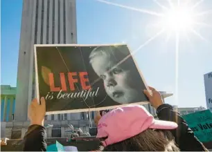  ?? ALICIA DEVINE/TALLAHASSE­E DEMOCRAT ?? An anti-abortion protester holds a sign outside the Florida Supreme Court after the court heard arguments on a proposed abortion amendment Wednesday in Tallahasse­e.