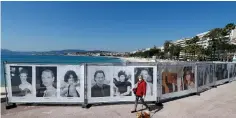  ?? (Eric Gaillard/Reuters) ?? A WOMAN walks past photos of the Cannes Film Festival on the Croisette in Cannes last week.