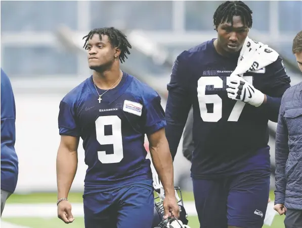  ?? — THE ASSOCIATED PRESS ?? Seattle Seahawks running back Ken Walker, left, walks with offensive tackle Charles Cross on Friday on the first day of the team's rookie mini-camp in Renton, Wash. Cross and fellow rookie Abraham Lucas are two of the just five offensive tackles listed on the team's roster.