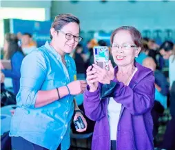  ?? PHOTOGRAPH COURTESY OF GLOBE TELECOM ?? ERLINDA Menor (right), 75, learns how to use GCash with the help of Cherry Lyn Lagdamen (left), GCash Training Specialist for NCR and Luzon, at Globe’s ‘Teach Me How to Digi’ #SeniorDigi­zen event, 25 January 2024.