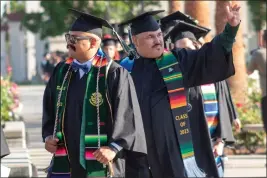  ?? PHOTOS BY GERARDO ZAVALA — DAILY DEMOCRAT ?? Woodland Community College graduates walk to their seats on the campus' courtyard Friday, May 26 in Woodland.