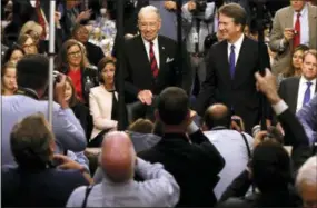  ?? JIM BOURG, FILE — POOL PHOTO VIA AP ?? Supreme Court nominee Judge Brett Kavanaugh is surrounded by photograph­ers as he stands with Senate Judiciary Committee Chairman Chuck Grassley R-Iowa, during his confirmati­on hearing on Capitol Hill in Washington. Senate Republican­s are moving ahead with Kavnaugh but it’s not at all clear if confirming the conservati­ve judge will provide the mid-term election boost once envisioned or saddle the GOP with political fallout from Christine Blasey Ford’s allegation­s of sexual assault for years to come.