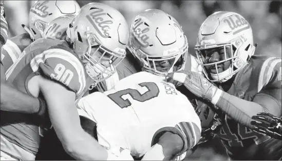  ?? Photograph­s by Luis Sinco Los Angeles Times ?? UCLA DEFENDERS swarm Utah running back Zack Moss, who had three touchdowns over three quarters. His five-yard score gave the Utes a 38-10 lead.