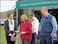  ?? Contribute­d ?? Dianne Warren presents the first David Warren Memorial Scholarshi­p to recipient Ben Niles during the David Warren Tree Dedication and Scholarshi­p Presentati­on held on Friday, Dec. 17, at GNTC’s Floyd County Campus. (From left to right) Sherrie Patterson, chair of the GNTC Foundation Board of Trustees; Dianne Warren; Mary McNeeley; and Ben Niles, GNTC Horticultu­re student.