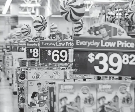  ?? [AP PHOTO] ?? With shoppers moving more seamlessly between stores and mobile devices, retailers are trying to find a balance between investing in both. Until now, Walmart’s goal was to keep store and online prices the same. But now it’s raising prices for certain...