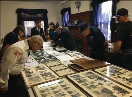  ?? CHARLES PRITCHARD - ONEIDA DAILY DISPATCH ?? Local residents and officials look over historic pictures and documents at the Canastota American Legion 100th anniversar­y on Saturday.