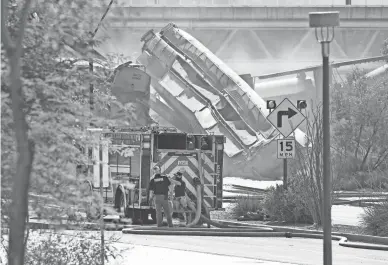  ?? ROB SCHUMACHER/THE REPUBLIC ?? A portion of the railroad bridge over Tempe Beach Park collapsed and several train cars hauling lumber burned over Tempe Town Lake on Wednesday.