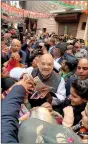  ??  ?? Home Minister Amit Shah distributi­ng pamphlets in Delhi Cannt.