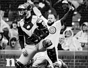  ?? NUCCIO DINUZZO/GETTY IMAGES ?? David Bote reacts after being safe at home in front of Yasmani Grandal during the fifth inning.