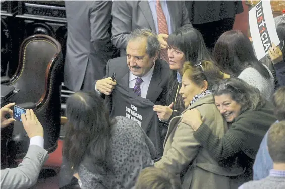 ?? GERARDO DELL’ORO ?? Satisfacci­ón. Familiares de víctimas de delitos, ayer, en el recinto de la Cámara de Diputados, junto al diputado Ricardo Alfonsín.