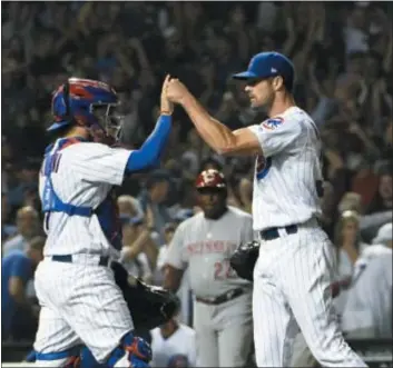  ??  ?? Cubs starter Cole Hamels, right, celebrates with catcher Victor Caratini after a win over the Reds last Thursday. The Phillies didn’t go to great lengths to acquire their former ace’s services at the non-waiver trade deadline, and the Cubs are happy they didn’t.