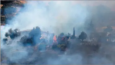  ?? PHOTOS BY ARIC CRABB — STAFF PHOTOGRAPH­ER ?? A structure burns as firefighte­rs work to put out a grass fire near Aborn Road and Gurdwara Avenue in Evergreen on Monday.